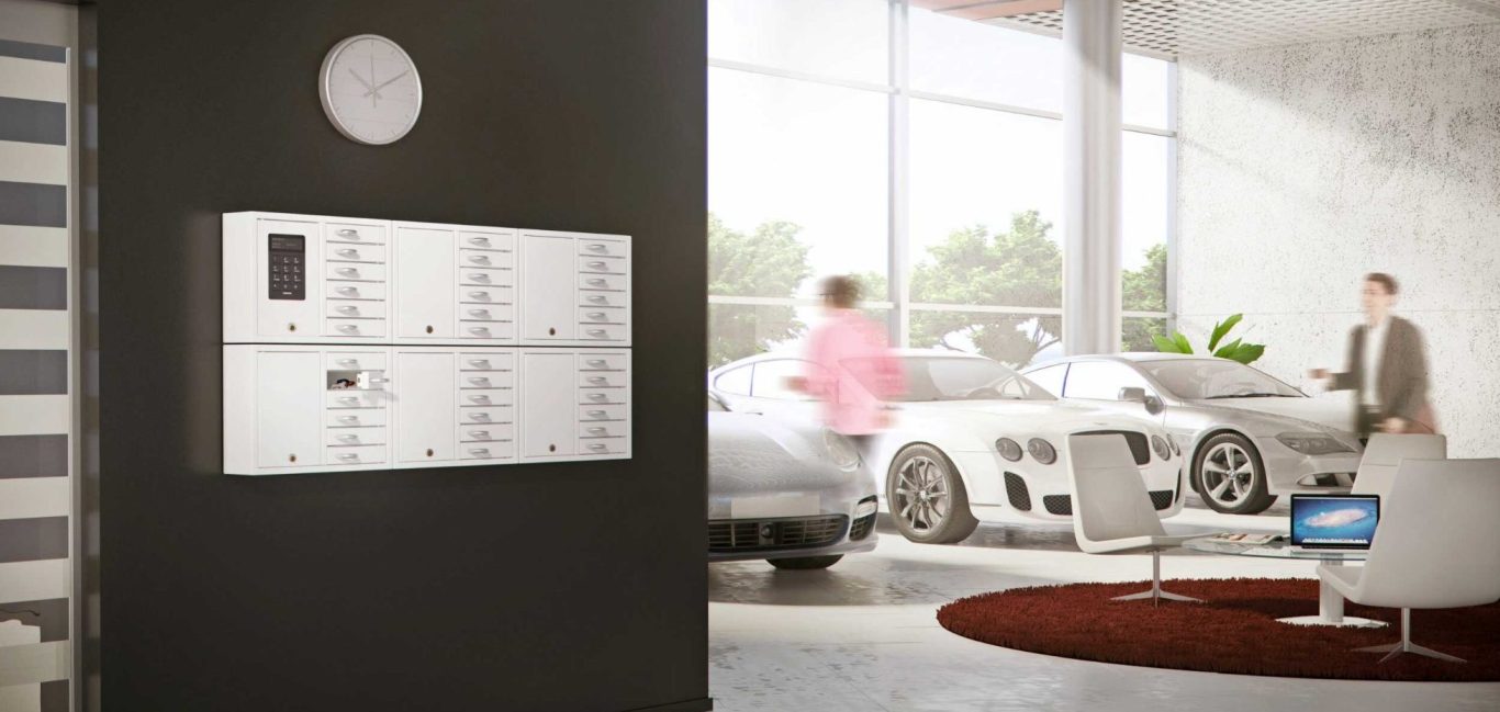 Intérieur moderne avec une armoire à clé Keybox System 9006 S avec armoires d'extensions, une voiture, des plantes et des personnes.